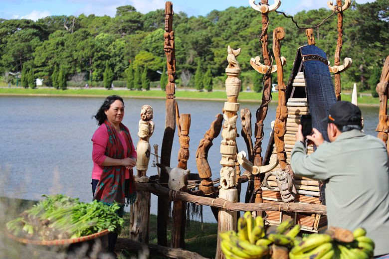 Du khách thích thú chiêm ngưỡng, chụp hình lưu niệm bên cả trăm bức tượng gỗ Tây Nguyên bên hồ Xuân Hương thơ mộng