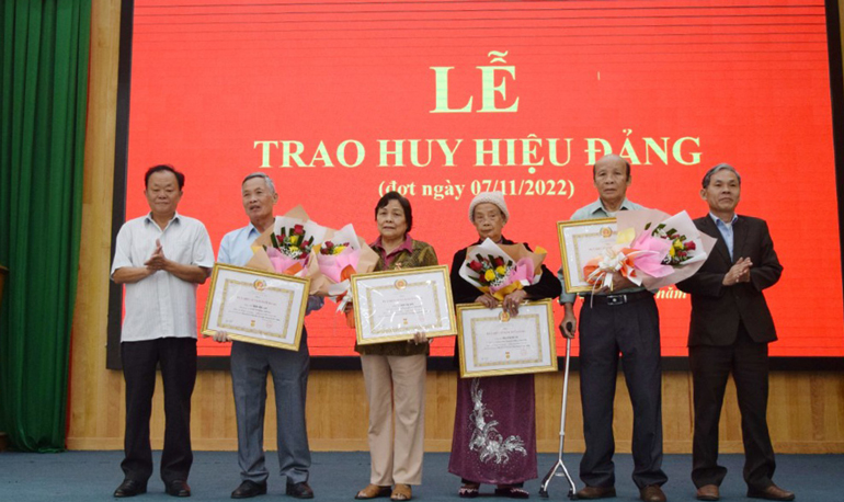 Đồng chí Lê Hồng Khánh – Phó Bí thư Thường trực Huyện ủy và đồng chí Nguyễn Văn Cường – Chủ tịch UBND huyện, trao huy hiệu Đảng cho đảng viên 55 tuổi đảng